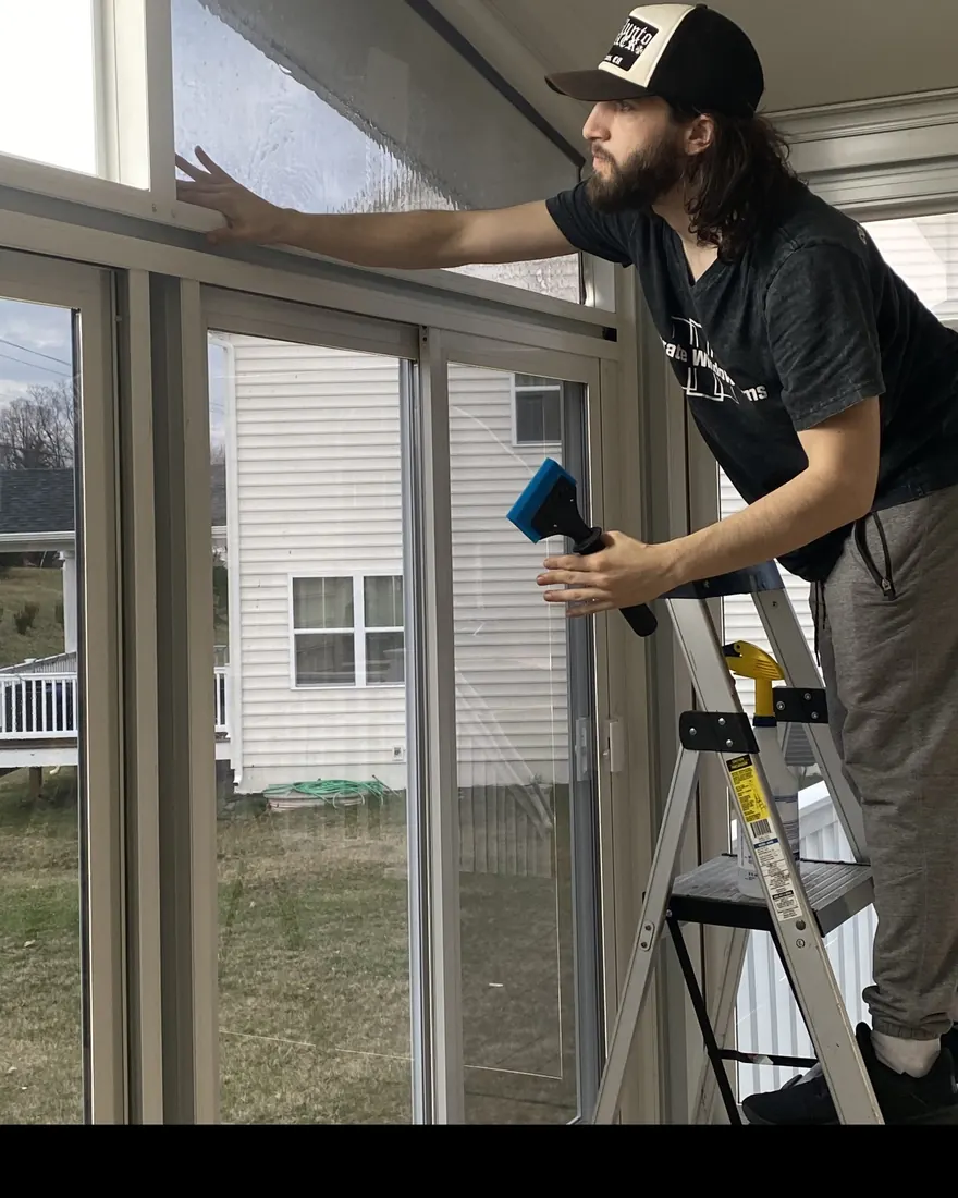 Corporate Window Films installer squeegeeing window film onto a home sunroom slider